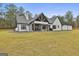 Exterior of modern farmhouse featuring a large backyard, covered patio, and stone and white siding at 285 Hogan Coweta Rd, Hogansville, GA 30230