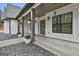 Spacious covered front porch featuring stylish pillars, decorative hanging plants, and rock landscaping at 285 Hogan Coweta Rd, Hogansville, GA 30230