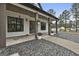 Covered front porch featuring dark wood beams, double doors, decorative wreaths, and stone landscaping at 285 Hogan Coweta Rd, Hogansville, GA 30230