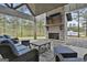 Covered patio with stacked stone fireplace, TV, and comfortable wicker furniture at 285 Hogan Coweta Rd, Hogansville, GA 30230