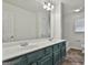Bathroom featuring a double sink vanity, a large mirror and a window with natural light at 205 Castlewood Rd, Tyrone, GA 30290