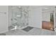 Bathroom features a glass enclosed shower with marble paneling, and tiled flooring and walls at 205 Castlewood Rd, Tyrone, GA 30290
