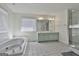 Bright bathroom with a jacuzzi tub, tiled floors, and a double sink vanity with a large mirror at 205 Castlewood Rd, Tyrone, GA 30290