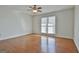 Open bedroom featuring hardwood floors, a ceiling fan, and a window offering natural light at 205 Castlewood Rd, Tyrone, GA 30290