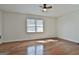 Open concept bedroom with hardwood floors, ceiling fan and a large window providing natural light at 205 Castlewood Rd, Tyrone, GA 30290