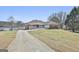 Expansive front exterior showcasing driveway, lakeside access and well-maintained lawn at 205 Castlewood Rd, Tyrone, GA 30290
