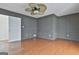 Spacious living room featuring dark walls, wood floors, and a ceiling fan at 205 Castlewood Rd, Tyrone, GA 30290