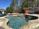 Backyard featuring a pool with a rock waterfall and ample seating for outdoor entertaining at 4683 Derby Loop, Fairburn, GA 30213