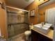 Bathroom featuring a glass shower with tiled walls, cream vanity, toilet, and decorative mirror at 4683 Derby Loop, Fairburn, GA 30213