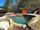 Beautiful pool area with lush landscaping, stone accents and outdoor furniture at 4683 Derby Loop, Fairburn, GA 30213