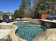 A beautiful backyard pool with stone features and comfortable patio furniture sits in a lush, green setting at 4683 Derby Loop, Fairburn, GA 30213