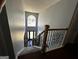 Elegant staircase with carpeted steps, wooden railings, and an abundance of natural light at 4683 Derby Loop, Fairburn, GA 30213