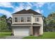 Charming two-story home featuring a brick facade, two-car garage, and well-manicured lawn at 10465 Trellis Lane (Lot 26), Hampton, GA 30228