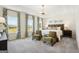 Bright main bedroom with large windows, tray ceilings, and plush seating area at 10465 Trellis Lane (Lot 26), Hampton, GA 30228