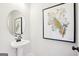 Stylish powder room featuring a pedestal sink, round mirror, and modern art at 10465 Trellis Lane (Lot 26), Hampton, GA 30228
