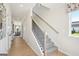 Elegant staircase featuring carpeted steps, light wood banister and large windows at 10465 Trellis Lane (Lot 26), Hampton, GA 30228