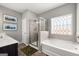 This bathroom features a soaking tub, glass enclosed shower, double sinks, and a window at 10471 Trellis Lane (Lot 25), Hampton, GA 30228