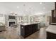 Open-concept kitchen with large island, stainless steel appliances, and view into the living area with fireplace at 10471 Trellis Lane (Lot 25), Hampton, GA 30228