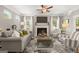 Cozy living room with fireplace, ceiling fan, and large windows providing ample natural light at 10471 Trellis Lane (Lot 25), Hampton, GA 30228