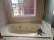 Relaxing bathtub area featuring a jacuzzi tub, providing a spa-like experience within the comfort of your home at 2765 Turning Leaf Dr, Lawrenceville, GA 30044