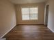Cozy bedroom with neutral walls, hardwood floors, and large window, offering a serene and comfortable space at 2765 Turning Leaf Dr, Lawrenceville, GA 30044