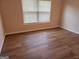 Bright bedroom featuring wood-look flooring and a window with blinds at 2765 Turning Leaf Dr, Lawrenceville, GA 30044