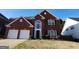 Charming brick home with a well-manicured lawn and two-car garage, providing an inviting curb appeal at 2765 Turning Leaf Dr, Lawrenceville, GA 30044