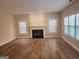 Bright living room with a cozy fireplace, hardwood floors, and large windows at 2765 Turning Leaf Dr, Lawrenceville, GA 30044