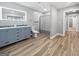 Bathroom with double vanity, lighted mirror, and a tub/shower with modern wood-look flooring at 102 Pinegate Rd, Peachtree City, GA 30269