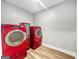 Bright laundry room featuring a red washer and dryer set with wood-look flooring at 102 Pinegate Rd, Peachtree City, GA 30269