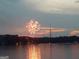 Fireworks explode in the sky over a lake at sunset at 102 Pinegate Rd, Peachtree City, GA 30269