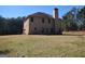 Rear view of home shows brick accents and spacious yard, mature trees around property at 276 Arborview Dr, Mcdonough, GA 30252