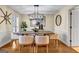 Elegant dining room featuring a rustic wooden table, modern chandelier, and neutral-toned chairs at 3736 Bloxham Ct, Atlanta, GA 30341