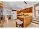 Well-lit kitchen featuring tile floors, island with stool seating, and staircase access at 3736 Bloxham Ct, Atlanta, GA 30341