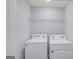 Bright laundry room featuring a white washer and dryer with overhead storage at 3232 Tarian Way, Decatur, GA 30034