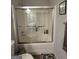Standard tub/shower combination featuring sliding glass doors, chrome fixtures and tile flooring at 1631 Royal Ives Dr, Lawrenceville, GA 30045