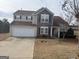 Two-story home featuring stone accents and a two-car garage on a well-manicured lawn at 1631 Royal Ives Dr, Lawrenceville, GA 30045