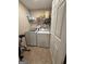 A small laundry room with standard washer and dryer and a wire rack for extra storage at 1631 Royal Ives Dr, Lawrenceville, GA 30045