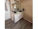 Bright bathroom vanity with white cabinets, laminate countertop, modern fixtures and wood-look flooring at 1631 Royal Ives Dr, Lawrenceville, GA 30045