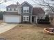 Charming two-story home with stone accents, attached garage, and tidy front yard landscaping at 1631 Royal Ives Dr, Lawrenceville, GA 30045