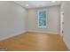 A room with light colored walls and hardwood floors featuring one window and one doorway at 553 Sommersby Dr, Dallas, GA 30157