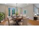 An arranged dining room with neutral colored chairs, a hardwood table, and a view of the forest outside at 553 Sommersby Dr, Dallas, GA 30157