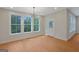 An empty dining room with hardwood floors, natural lighting, and modern light fixture at 553 Sommersby Dr, Dallas, GA 30157