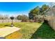 Fenced-in backyard features a small patio area, green grass, and mature trees, offering a private retreat at 261 Whistle Way, Locust Grove, GA 30248