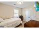 A cozy bedroom with a white comforter, light-colored walls, and natural light from a window at 261 Whistle Way, Locust Grove, GA 30248
