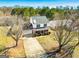 Two story home featuring red shutters, neutral siding, a long driveway, and beautiful landscaping at 261 Whistle Way, Locust Grove, GA 30248