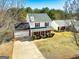 Two story home featuring red shutters, neutral siding, well-maintained landscaping, and a long driveway at 261 Whistle Way, Locust Grove, GA 30248