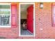 Inviting front entryway with a red door, brick facade, shuttered windows, and a cozy, open ambiance at 261 Whistle Way, Locust Grove, GA 30248
