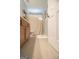 Bathroom features a light tile floor, wooden vanity and a shower with a beige curtain at 5790 Ridge Stone Way, Cumming, GA 30041