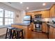 Well-lit kitchen with stainless steel appliances, wood cabinets, black countertop seating, and hardwood floors at 5790 Ridge Stone Way, Cumming, GA 30041